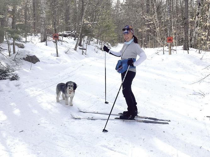 Nordic Tracks - woman and dog on Bear Notch Ski Touring Center's trails