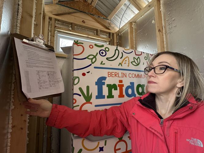 Magen Moreau reviews the checks made by volunteers of the community fridge