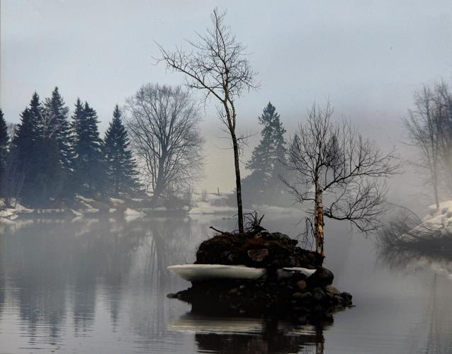 Mist falls on the Androscoggin River in this photograph of boom piers