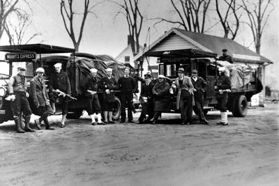 Coast Guardsmen stand in front of two truckloads of liquor seized on April 14, 1931, after a battle between three policemen and several alcohol smugglers near Falmouth, Mass.
