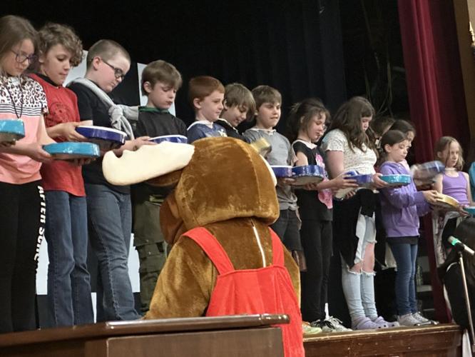 The school mascot faces the students on stage