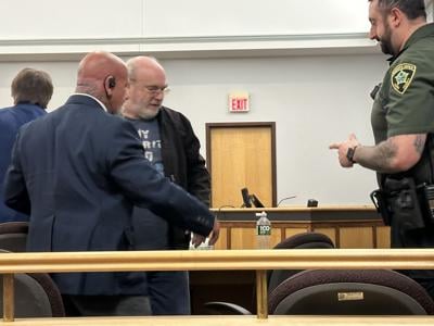 Richard R. Devoid, center, is taken into the custody of the Coos County Sheriff's Department