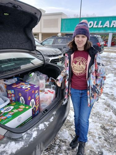 Cadette Girl Scout Wednesday Belanger shows some of the items that will go in the Willard Street Little Free Pantry