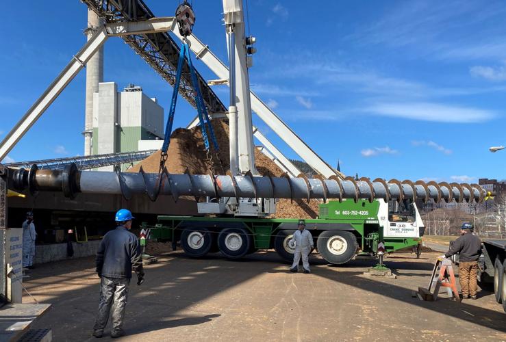 Burgess BioPower workers perform maintenance on a reclaim screw.