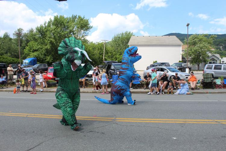Two parade volunteers dressed as dinosaurs at the July 4 parade