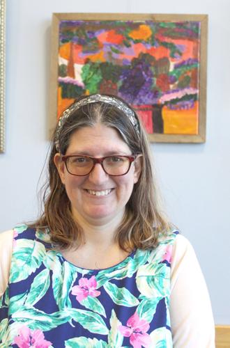 Lily May Jenkins stands in front of one of her paintings