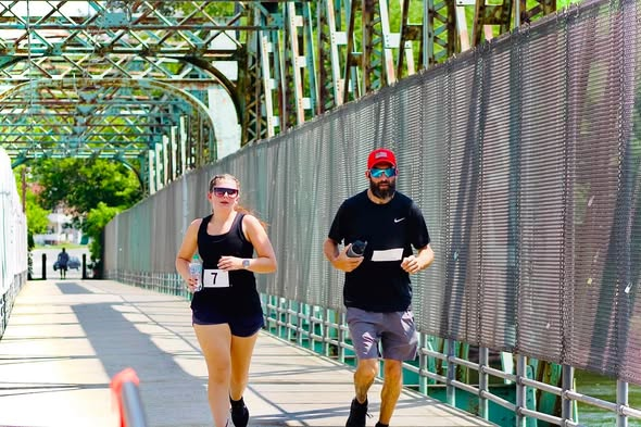 Two runners cross the so-called Green Bridge that spans the Androscoggin River