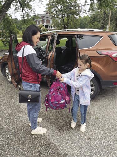 handing daughter backpack