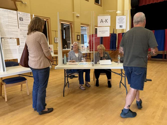 Gorham poll workers Victoria Hill (left) and Grace Lapierre check in two residents