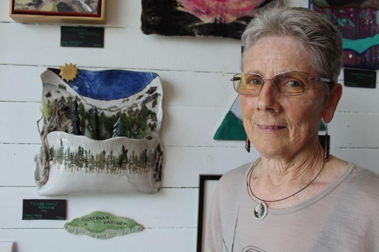 Cheryl White, of Gorham, poses by the clay artwork she created of Tuckerman Ravine
