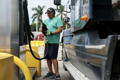 With fuel prices at record highs, a truck driver prepares to pump diesel into a tractor trailer at a gas station in Florida.