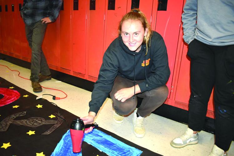 Senior McKenna Kelley drying a poster