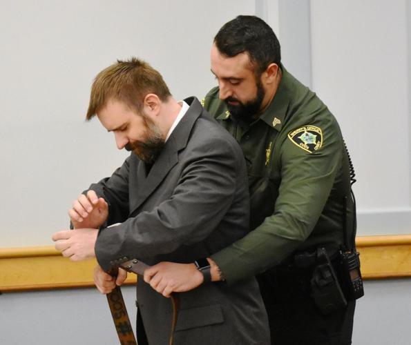 A member of the Coos County Sheriff's Office takes convicted murderer Dustin Duren into custody
