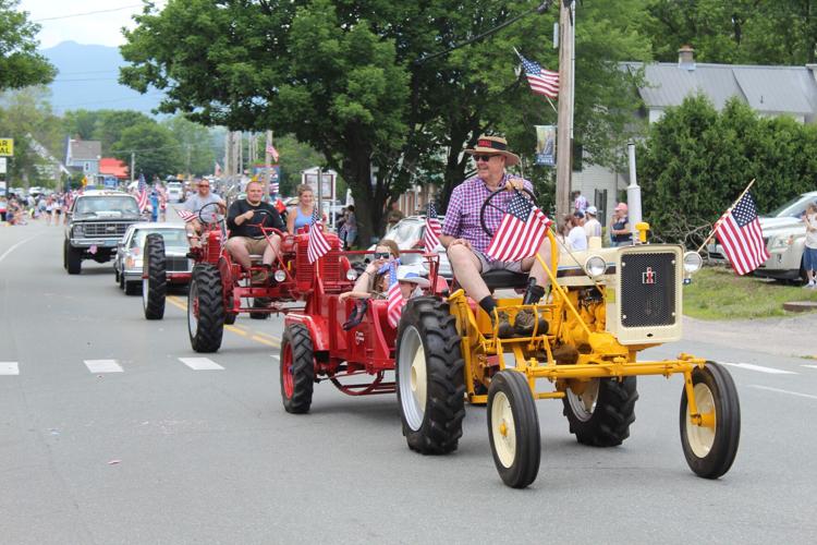 A trio of tractors and their riders roll down Main Street during the July 4 parade