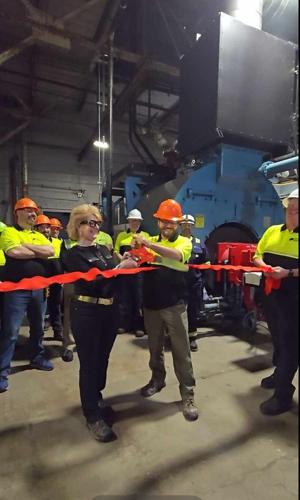 Claudia Hunt, vice president of finance at White Mountain Paper Co. in Gorham, (at left) cuts the ceremonial ribbon