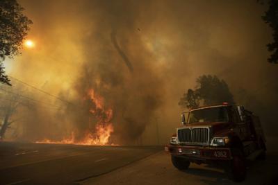 A fire whirl, or fire tornado, rises from flames near Wofford Heights, Calif., in August 2021.