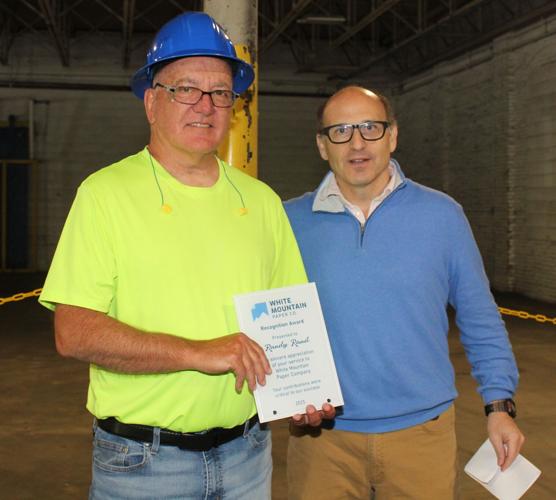 Randy Rand receives a recognition award from Evan Behrens f