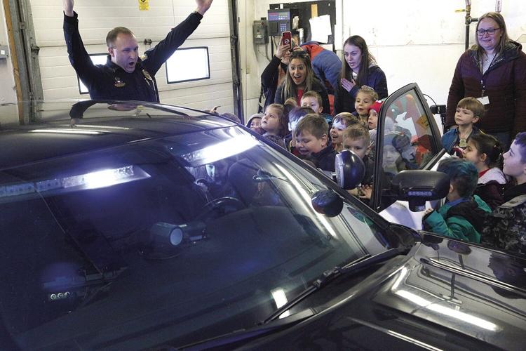 12-21-22 Gingerbread Hunt pd looking in cruiser cheering