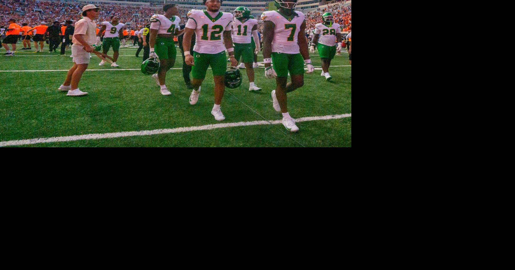 Oregon players walk off the field as fans storm the field as the Oregon Ducks face the Oklahoma State Cowboys on Sept. 12, 2026, at Boone Pickens Stadium in Stillwater, Oklahoma.
