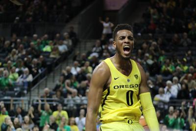 Oregon's Troy Brown, left, shoots while covered by Washington