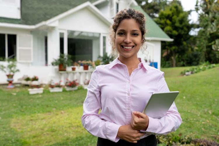 Portrait of a real estate agent outside a beautiful suburb house