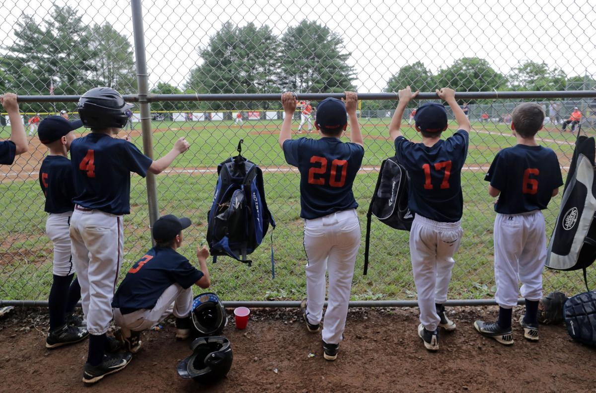 Youth Baseball Player Behind The Dugout Fence During A Game In