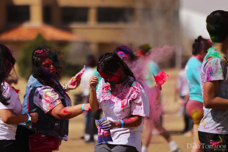 Students throw pink Holi powder