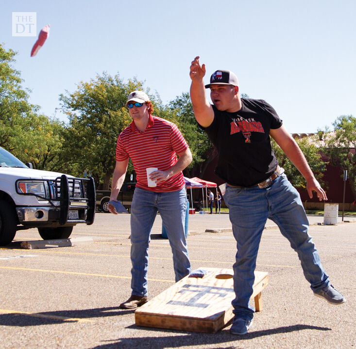 People tailgate and play corn hole beofre the game