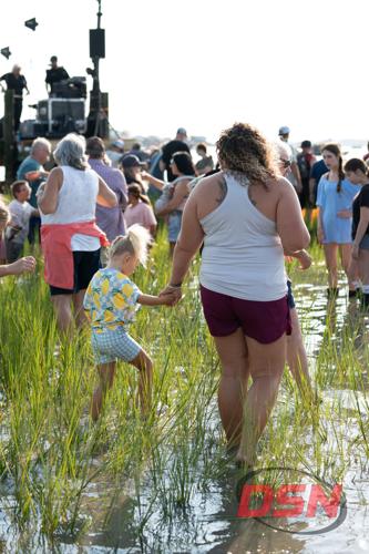 Mother and daughter holding hands walking through the marsh.jpg