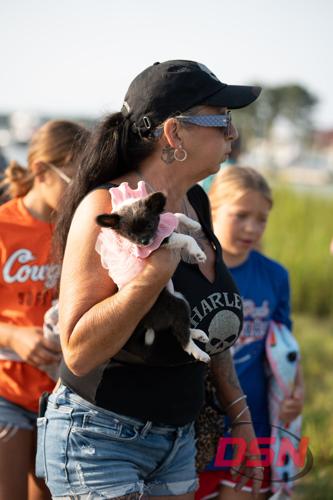 Woman holding a puppy in a pink outfit.jpg