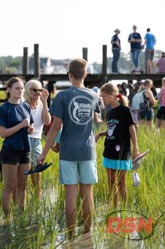 Teens holding sandals while chatting in the marsh.jpg