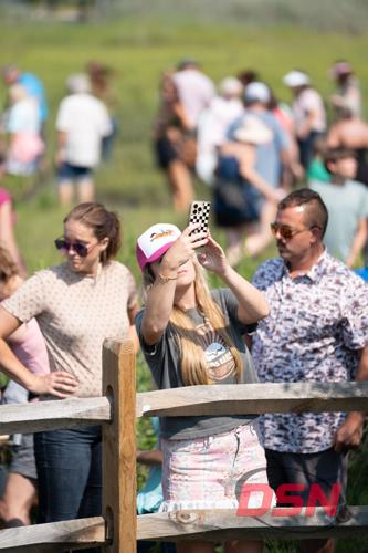 Woman in a pony hat photographing over the fence.jpg