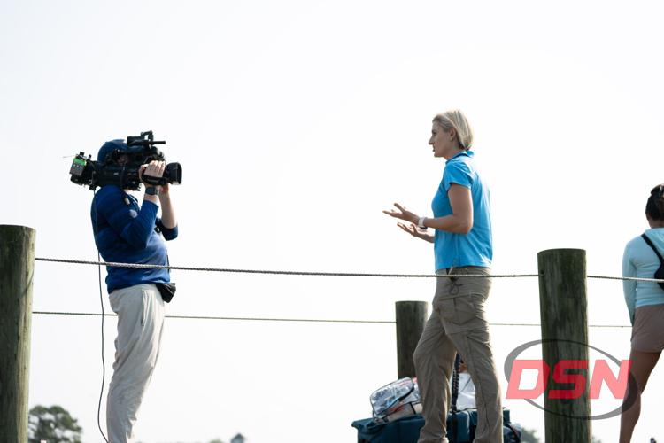 Reporter gesturing while being filmed on the dock.jpg