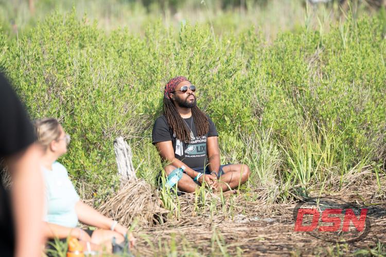 Man sitting in the marsh grass wearing sunglasses.jpg