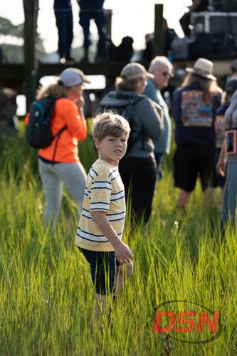 Boy standing in the marsh grass among the crowd.jpg