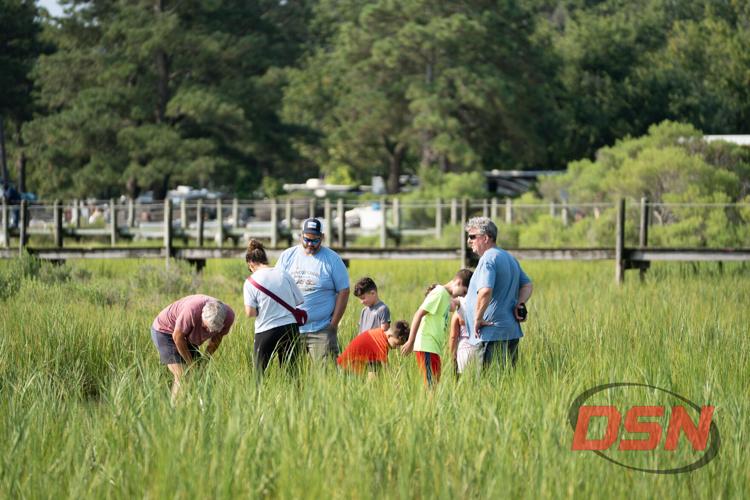 Family exploring the tall marsh grass near the docks.jpg