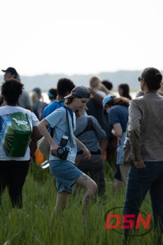 Photographer with a vintage camera walking through the marsh grass.jpg