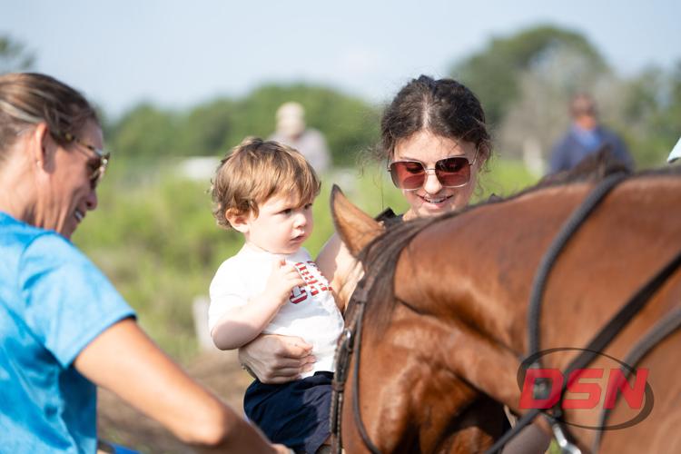 Mother holding a toddler beside a horse.jpg