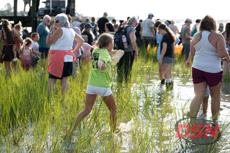Girl carrying a sandal while running through the marsh.jpg