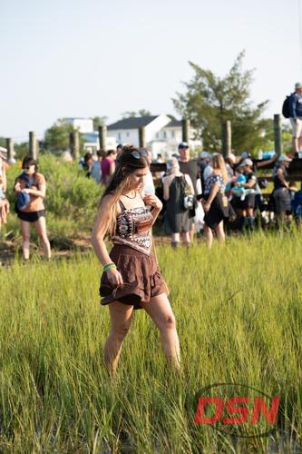 Woman in a boho outfit walking barefoot through the marsh.jpg