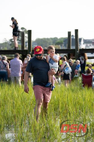 Man in a Bass Pro hat carrying a toddler through the marsh.jpg