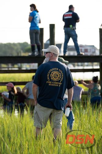 Chincoteague Volunteer Fireman watching the crowd from the marsh.jpg