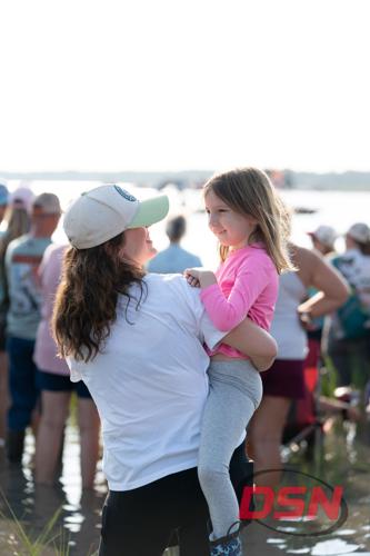 Mother smiling at her daughter she is carrying by the water.jpg