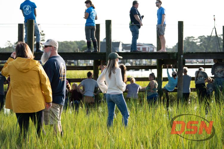 Spectators standing on the pier and in the marsh grass.jpg