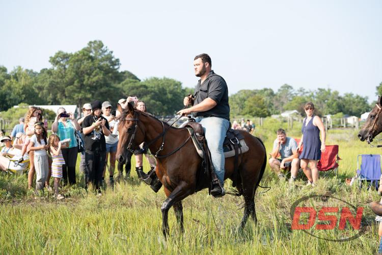 Crowd photographing a Saltwater Cowboy riding through the marsh.jpg