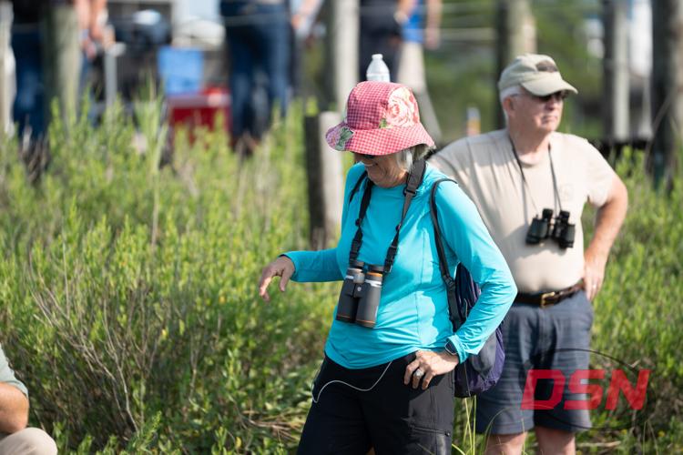 Woman with binoculars laughing in the marsh grass.jpg
