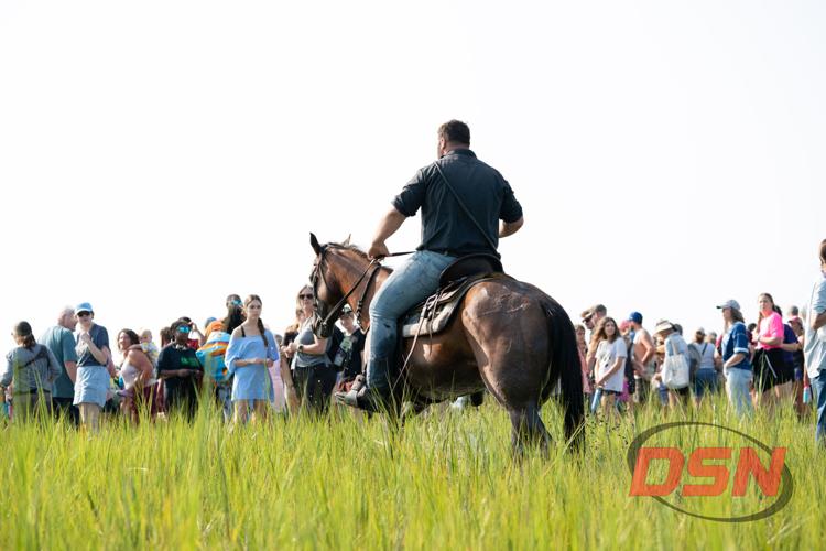 Saltwater Cowboy riding through the marsh in front of a large crowd.jpg