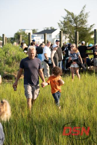 Father and son walking hand in hand through the marsh.jpg