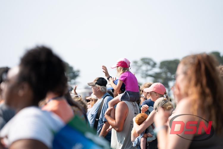 Girl waving from her father's shoulders in the crowd.jpg