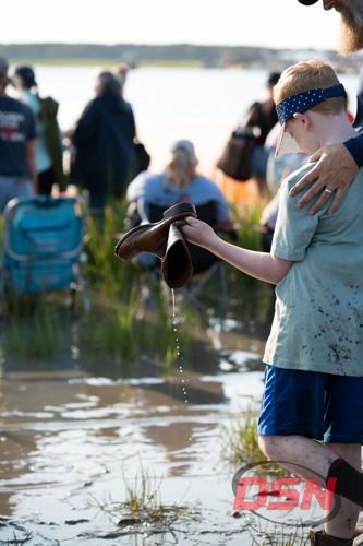Boy holding muddy boots with his dad.jpg